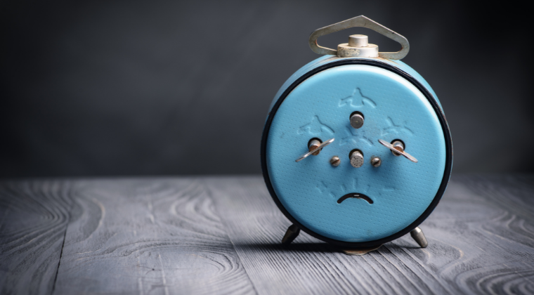 blue alarm clock with sad face